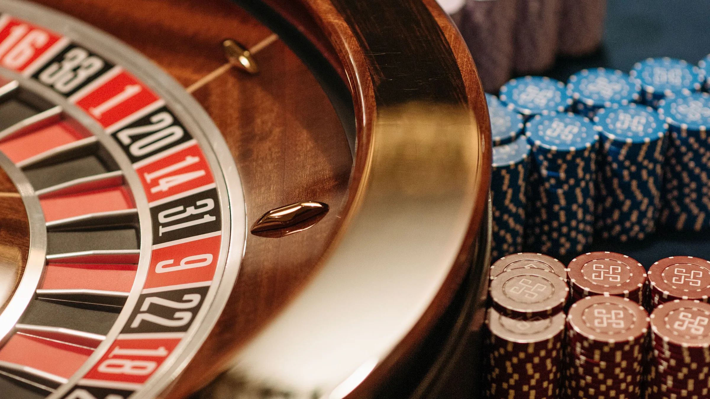 Roulette wheel and stacks of coloured casino chips on a felt table