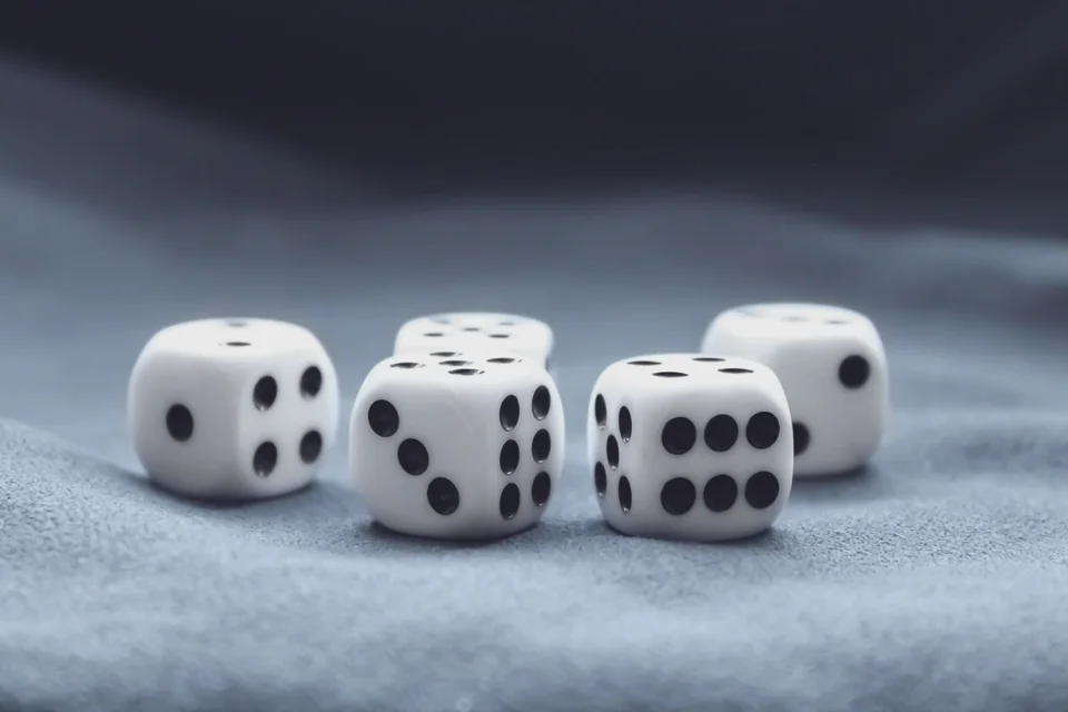 A collection of white dice on a textured grey surface