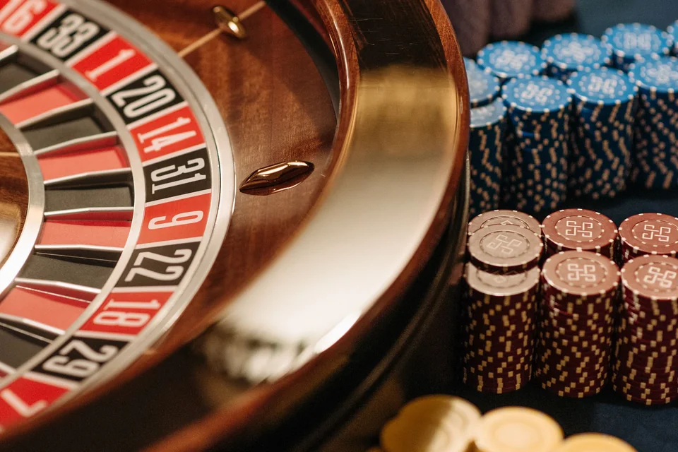 Roulette wheel and stacks of coloured chips on a felt table